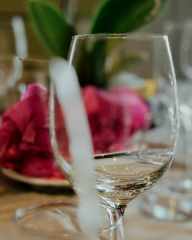 Copas sobre la mesa puesta, con flores en el centro