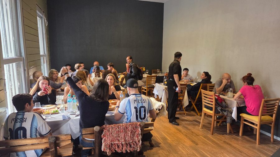 El salón lleno, con mesas largas y gente almorzando